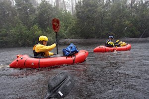 Two rafters paddling in the rain