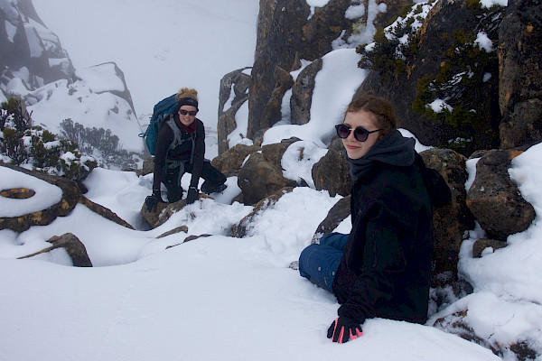 Walkers on a snow-covered boulder scramble