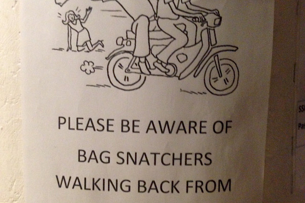 Sign that reads, “Please be aware of bag snatchers walking back from La Fevela!!!”
