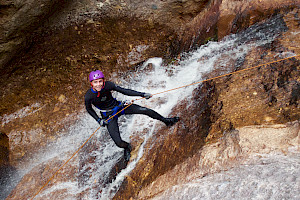 A male abseiling down a waterfall