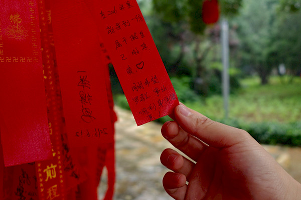 Hand holding a strip of red silk