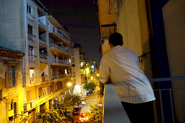 Person looking over a balcony at the street at night